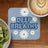 Blue coaster with "DEEP BREATHS" and daisies, next to coffee and kiwi.