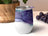 White tumbler with purple, blue, and green glitter abstract design.