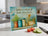 Glass cutting board with Proverbs 15:17 quote and herbal garden illustration.