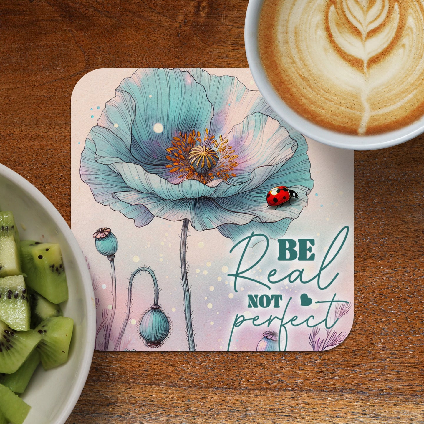 Blue poppy floral coaster with "Be Real Not Perfect" text and a ladybug.