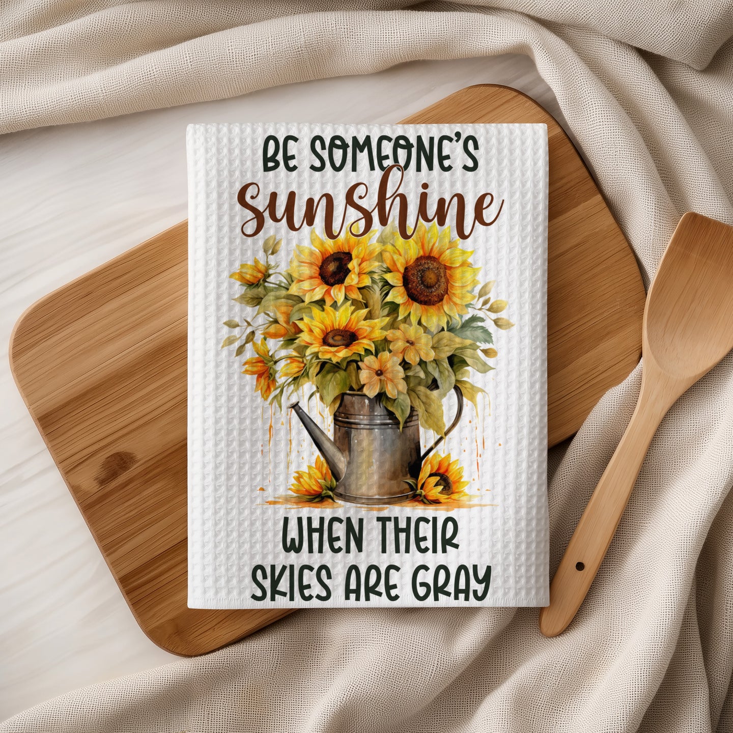 White waffle weave towel with sunflowers in a watering can and text.