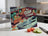 Vegetable characters peek from drawers above a knife and sliced tomatoes and cucumbers.