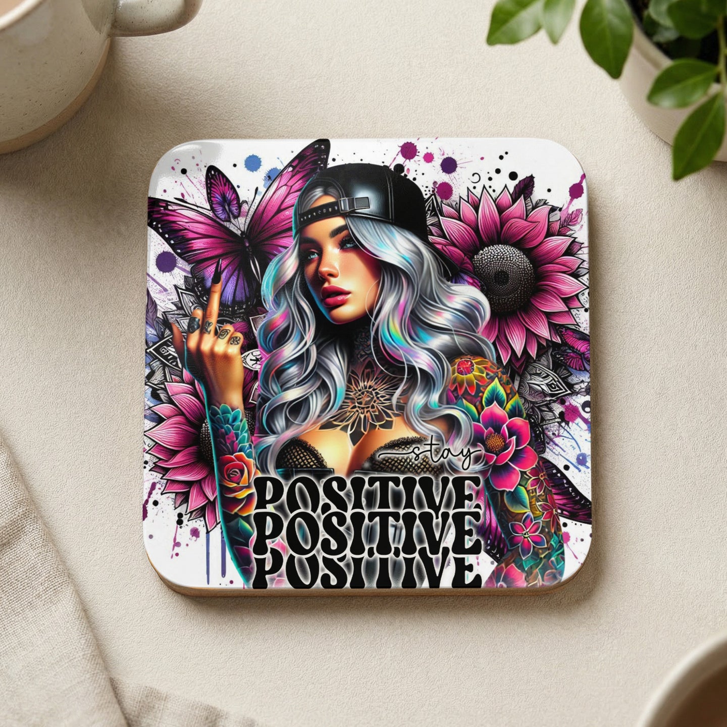 Woman with tattoos and colorful butterflies, surrounded by flowers, saying "stay positive."