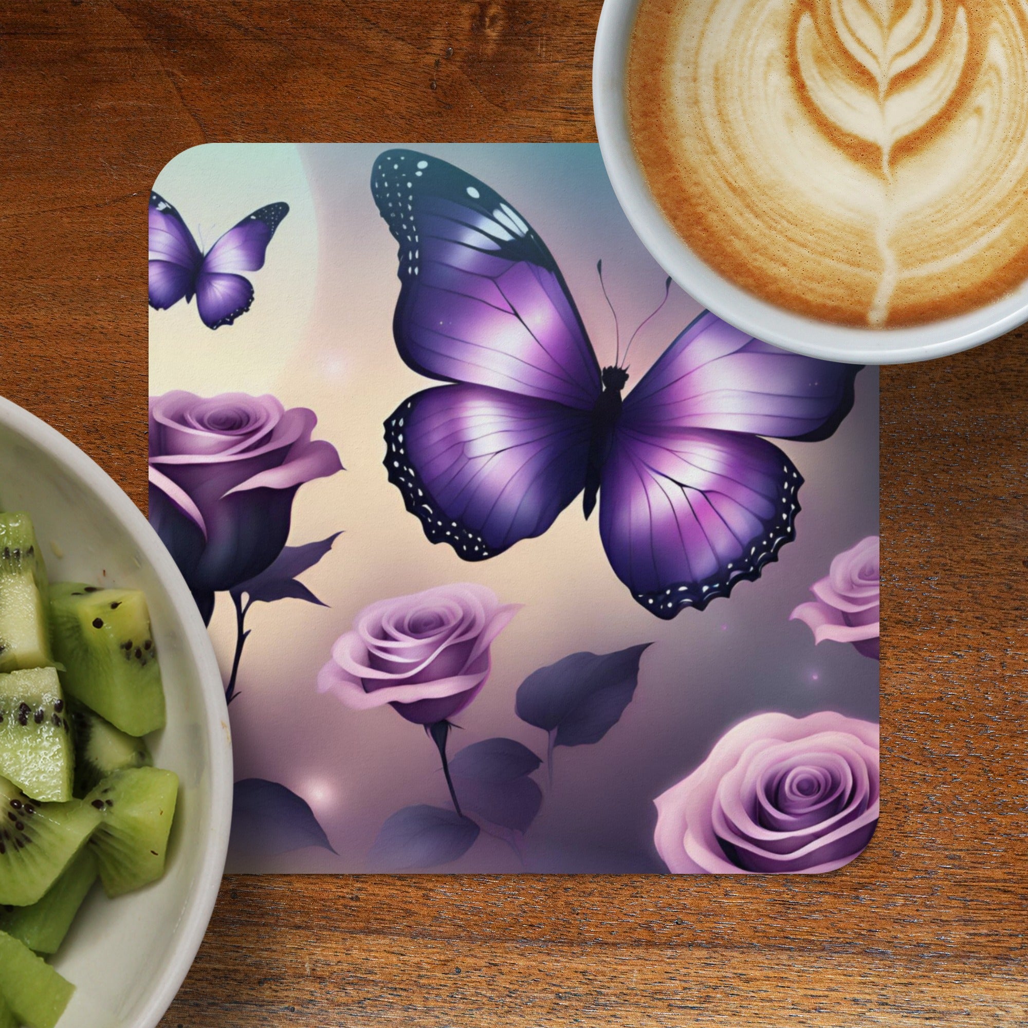 Purple butterfly and roses design on a coaster next to coffee and kiwi.