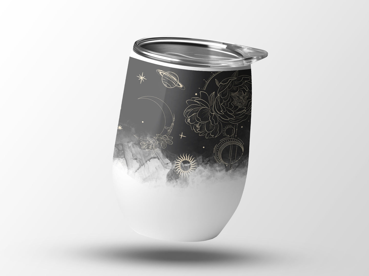 White tumbler with gold celestial and floral designs, suspended in air.