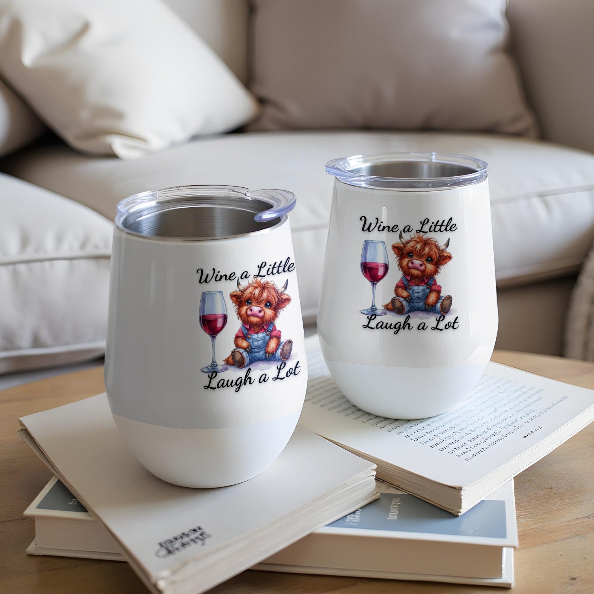 Two wine tumblers with a cartoon cow and wine glass, reading "Wine a Little, Laugh a Lot."