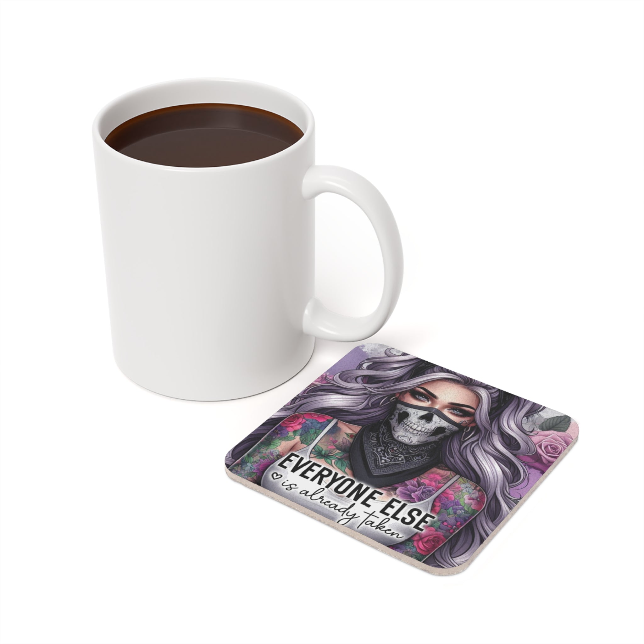 White mug next to square coaster with tattooed woman and text "Everyone Else Is Already Taken".