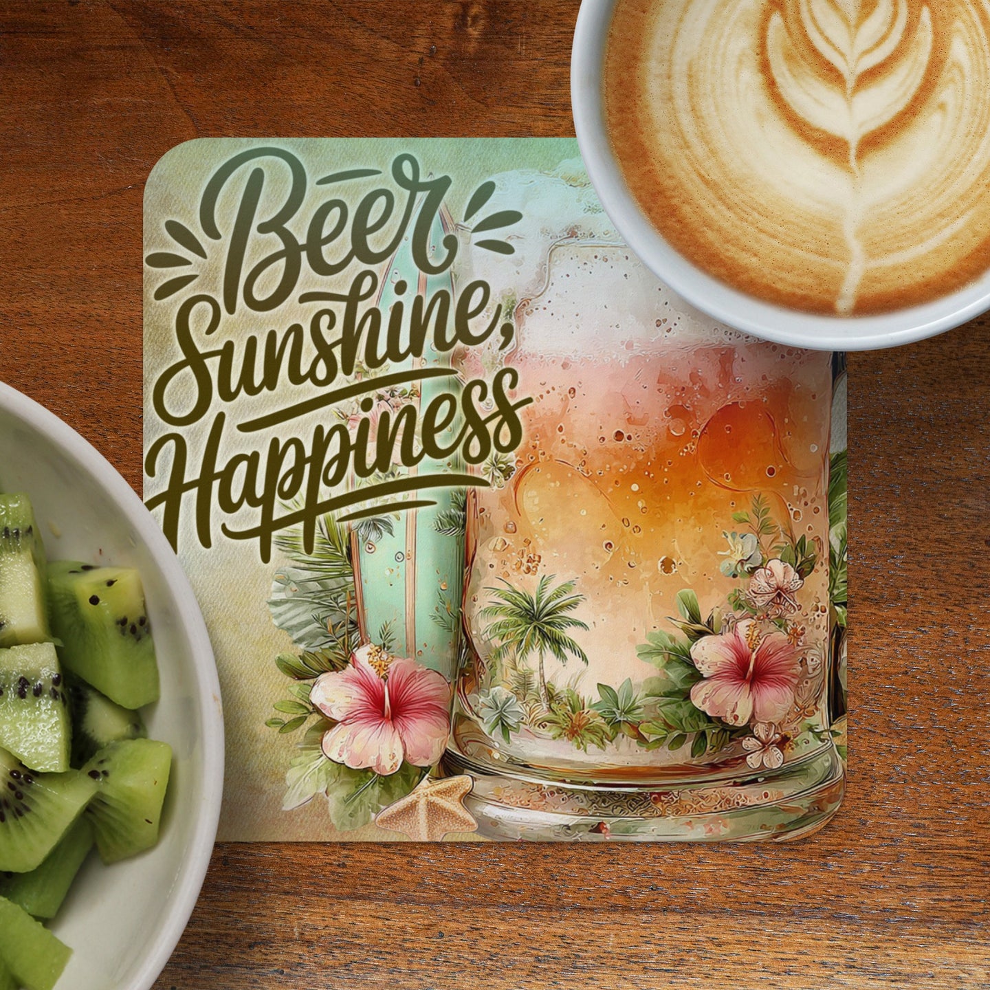 Coaster with "Beer Sunshine Happiness" text and tropical scene beside coffee and kiwi.