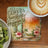 Coaster with "Beer Sunshine Happiness" text and tropical scene beside coffee and kiwi.
