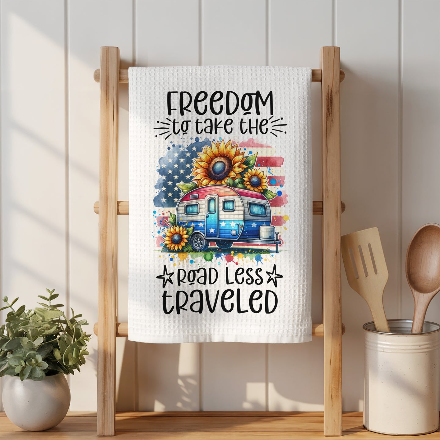 American flag camper with sunflowers and "Freedom to take the road less traveled" text.