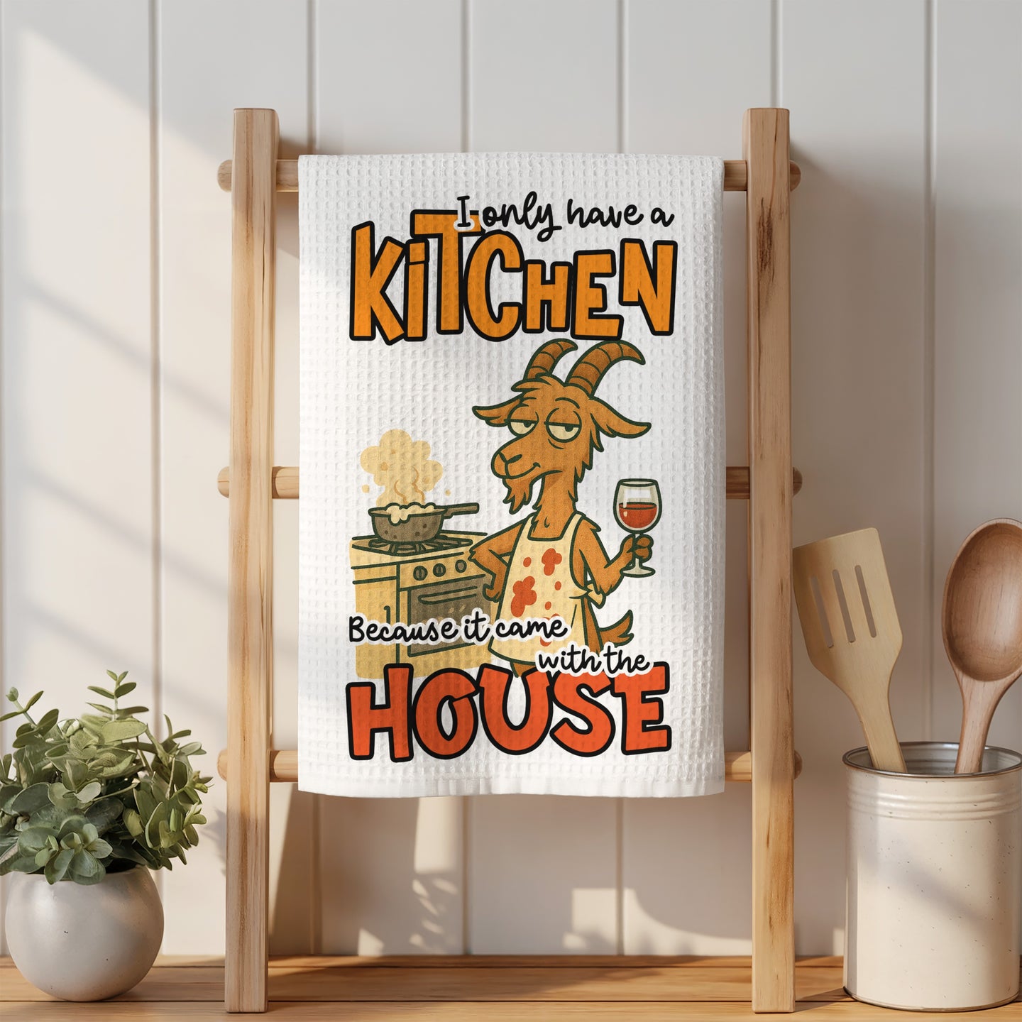 Waffle towel with a cartoon goat in an apron holding a wine glass.