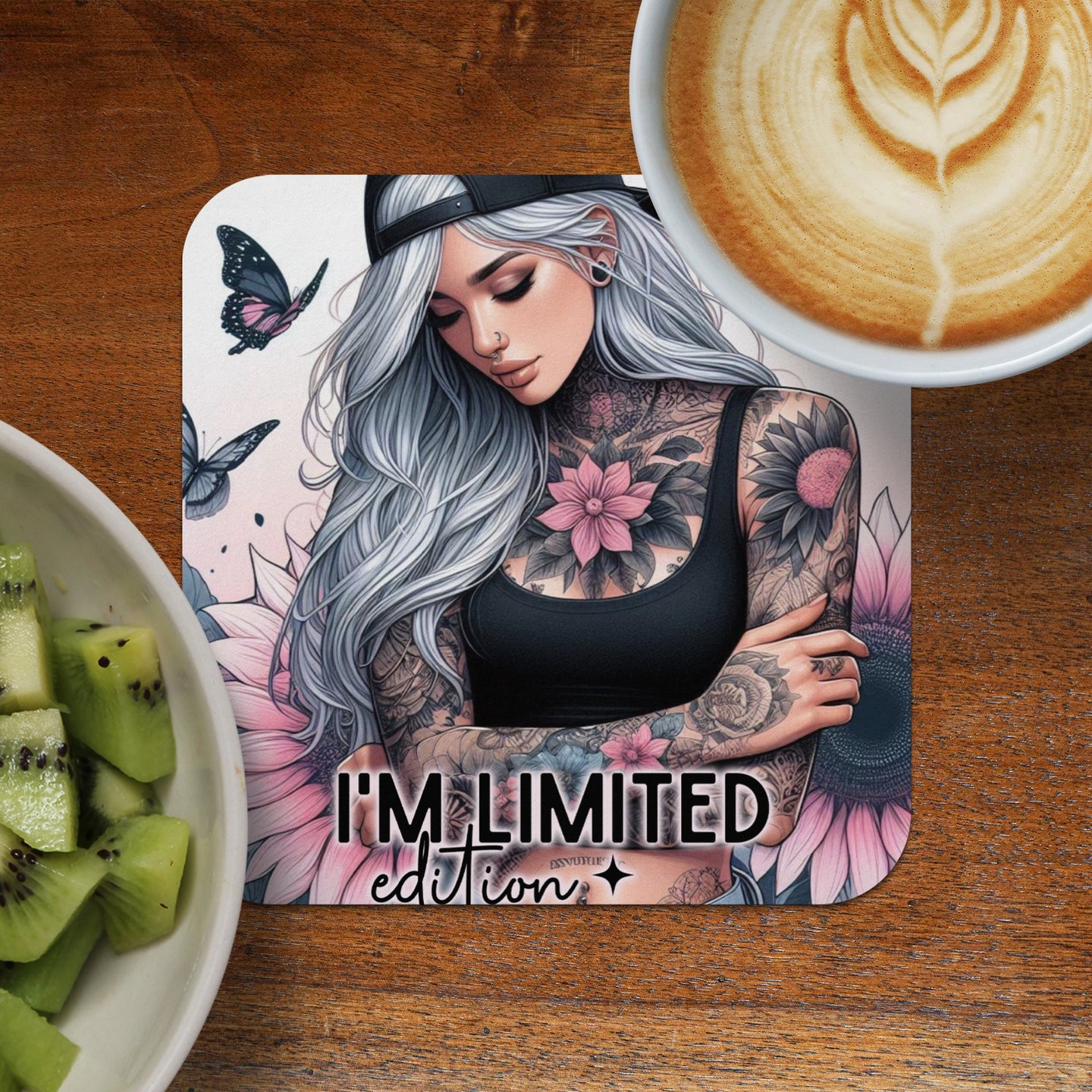 Tattooed woman with grey hair wearing a black tank top and baseball cap.