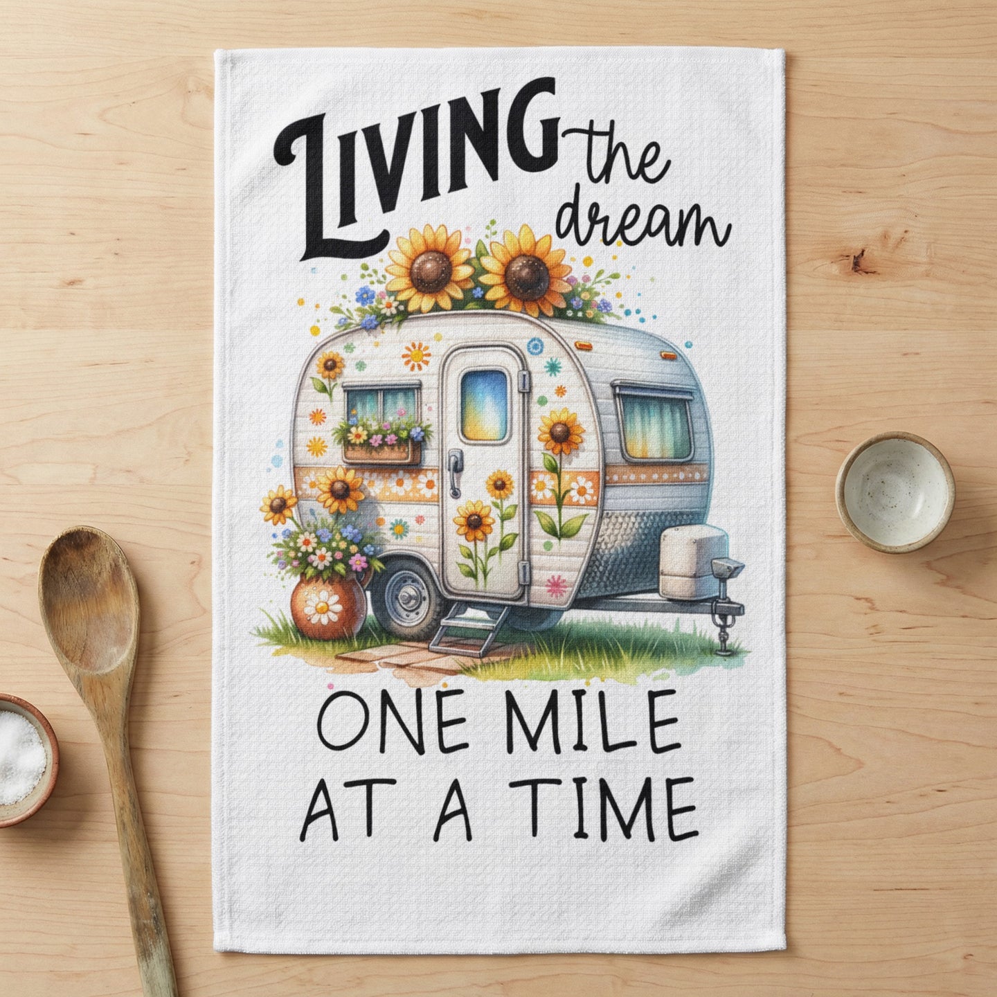 Camper with sunflowers and text "Living the dream one mile at a time".
