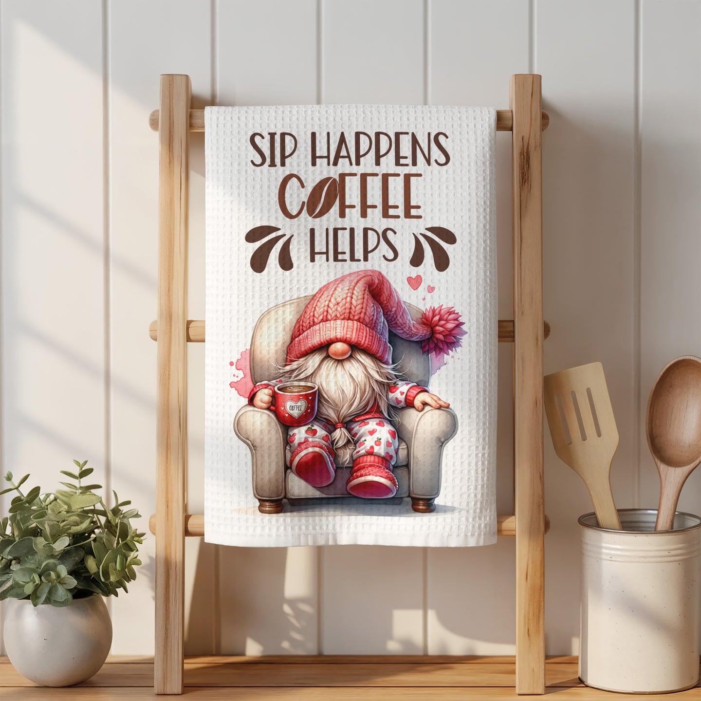 Gnome in armchair with coffee mug on a kitchen towel, reads "Sip Happens Coffee Helps."