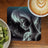 Fairy with glowing hair on dark background, near coffee and kiwi.