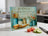 Cutting board with recipe text, jar ingredients, cupcake, and vegetables.