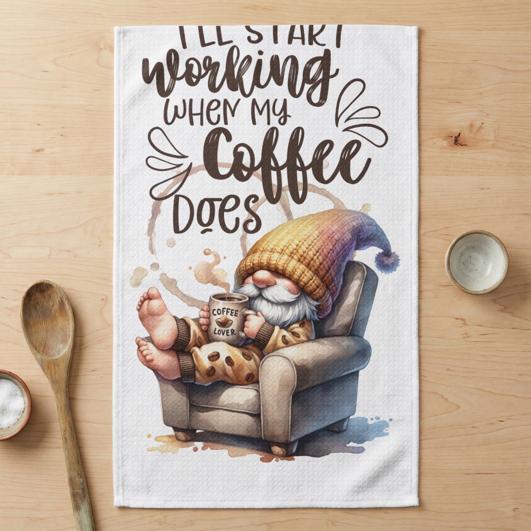 Cozy gnome in armchair holding coffee cup, text reads "I'll start working when my coffee does".