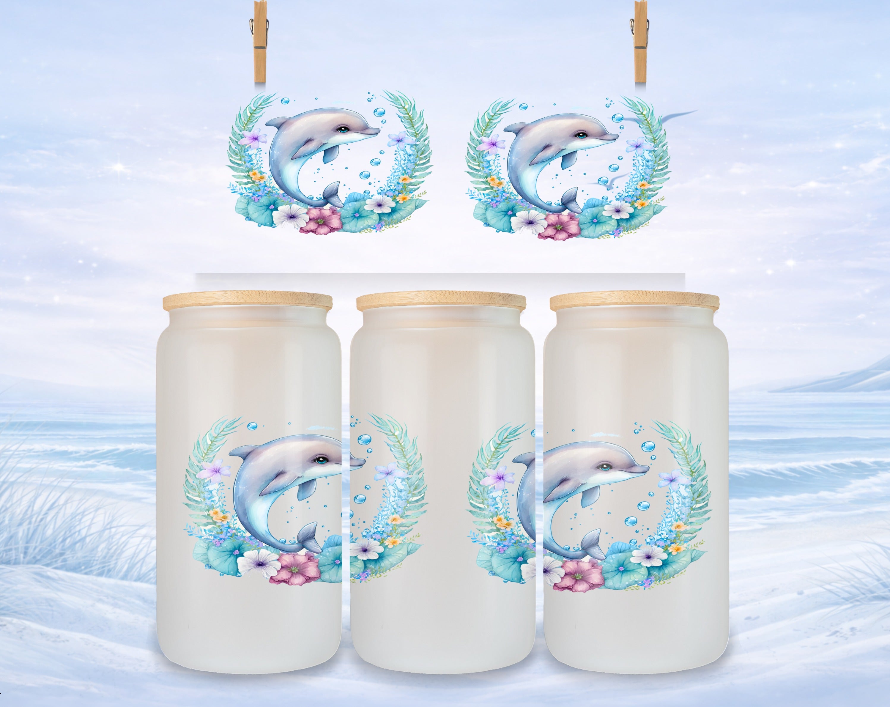 Three frosted glass tumblers with dolphin and floral wreath designs.
