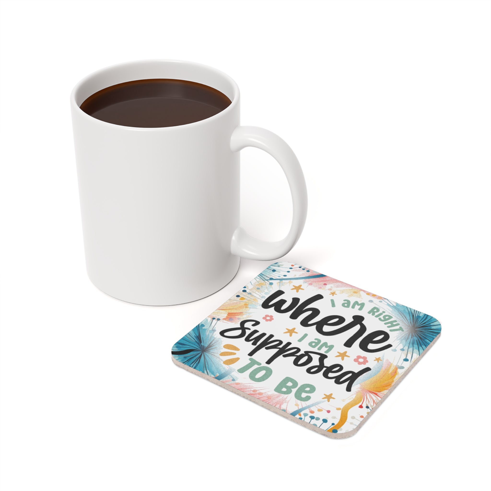 White mug of coffee next to a coaster with "I am right where I am supposed to be" text.
