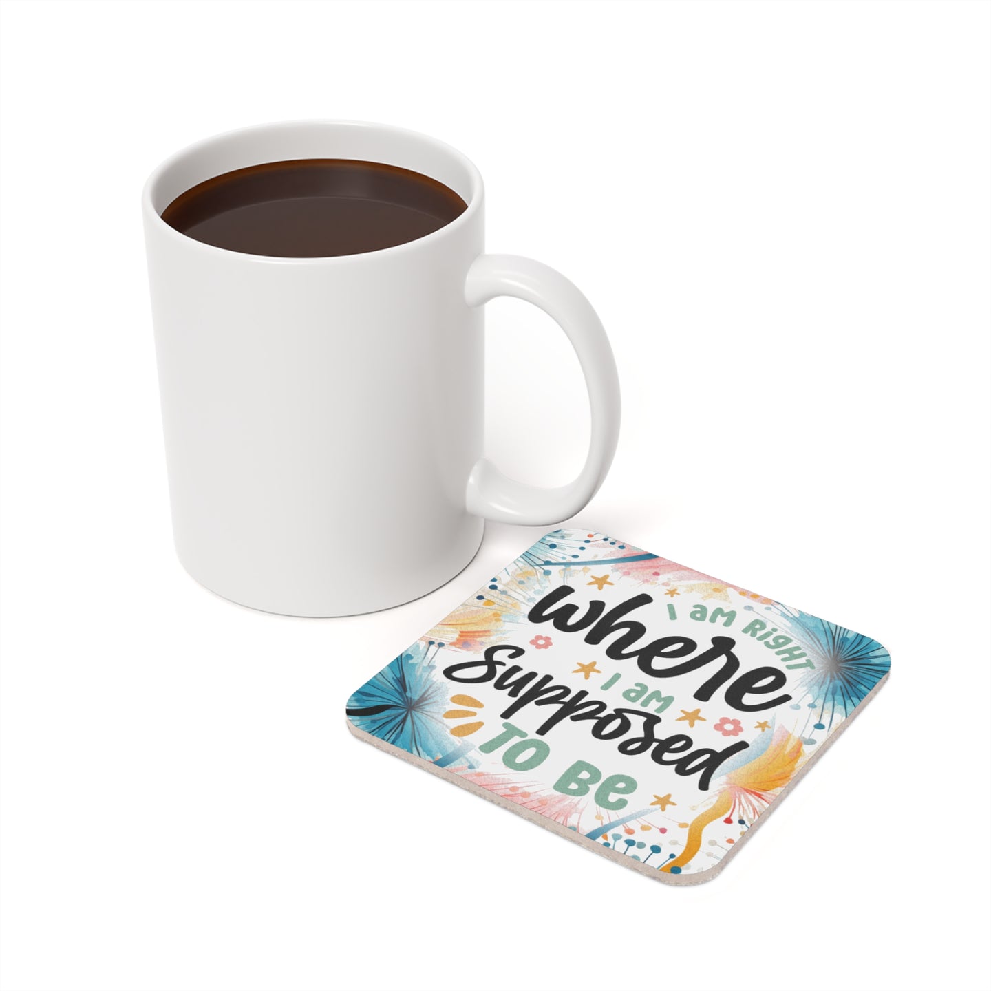 White mug of coffee next to a coaster with "I am right where I am supposed to be" text.