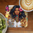 Coaster with woman's portrait and "Bach Day Is Beginning" text, near coffee and kiwi.