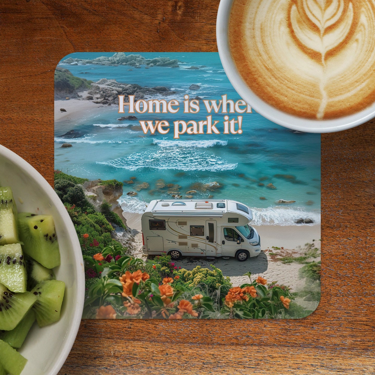 Camper van parked on a beach with a coffee and kiwi fruit.