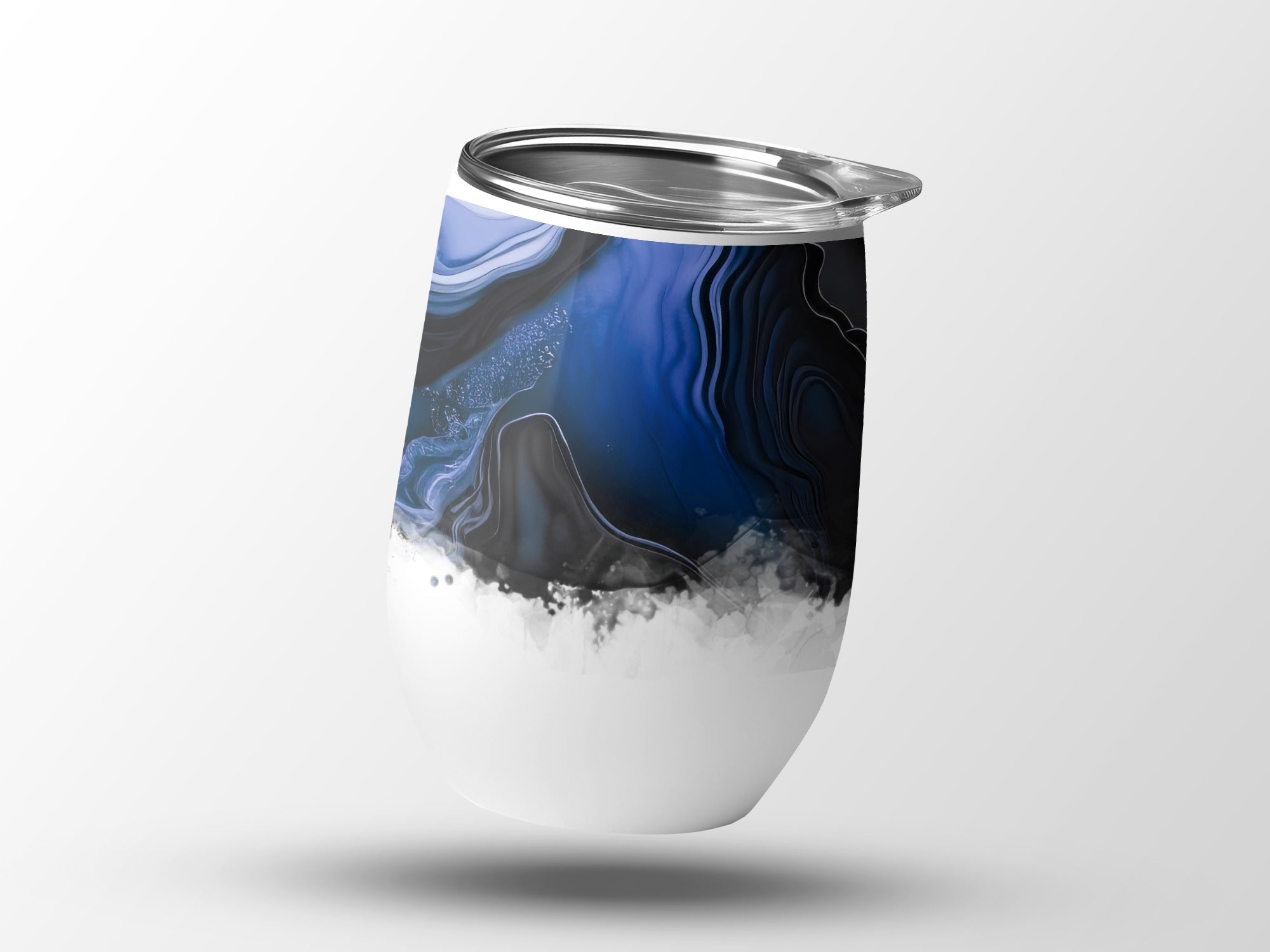 White tumbler with abstract blue and black marbled design at the top.
