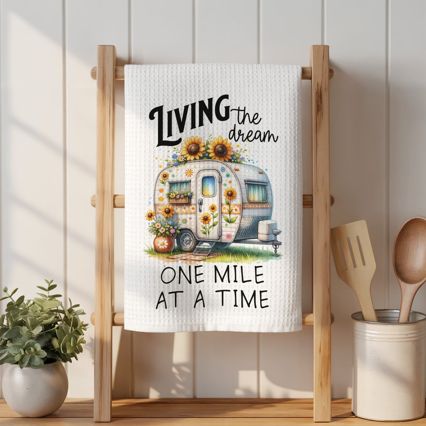 Camper with sunflowers and text "LIVING the dream ONE MILE AT A TIME".