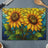 Two stained-glass sunflowers with green leaves on a blue and yellow background.