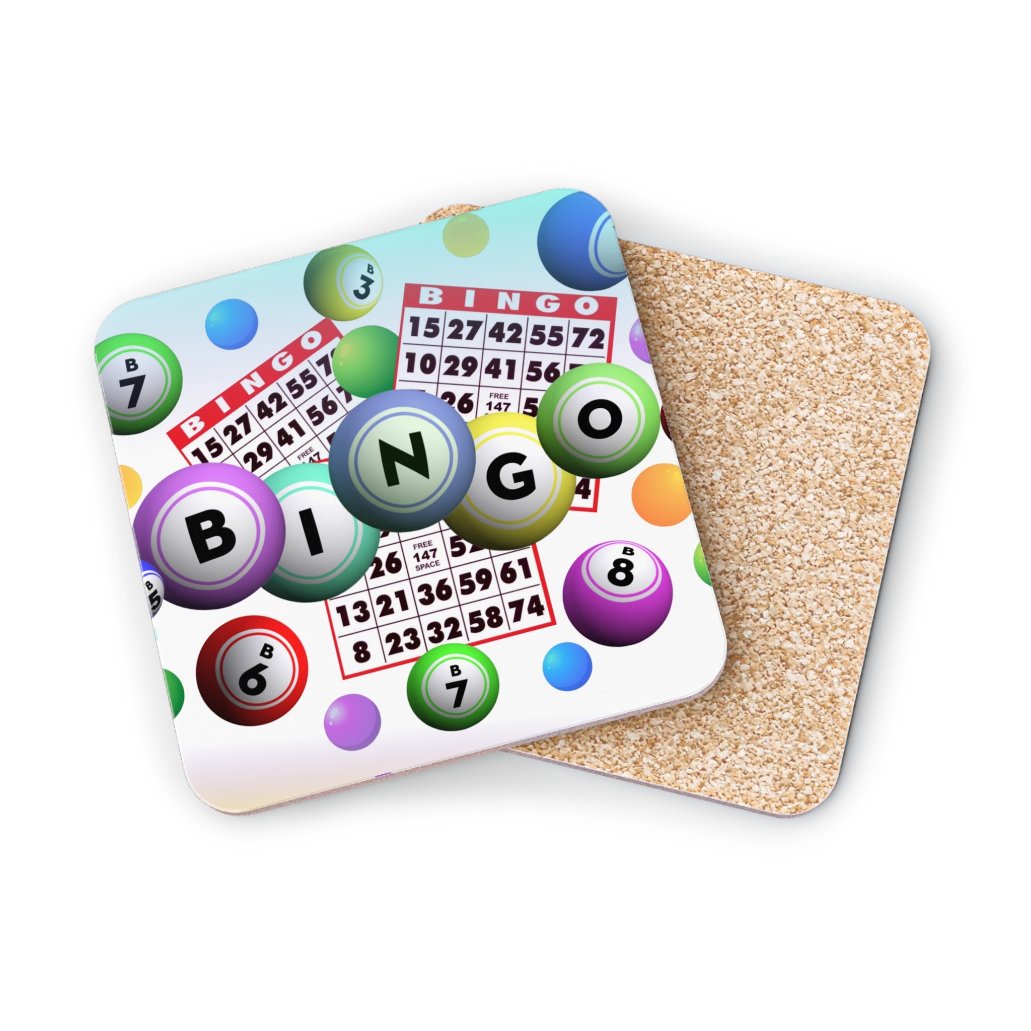 Bingo cards and colorful bingo balls on a textured cork coaster.