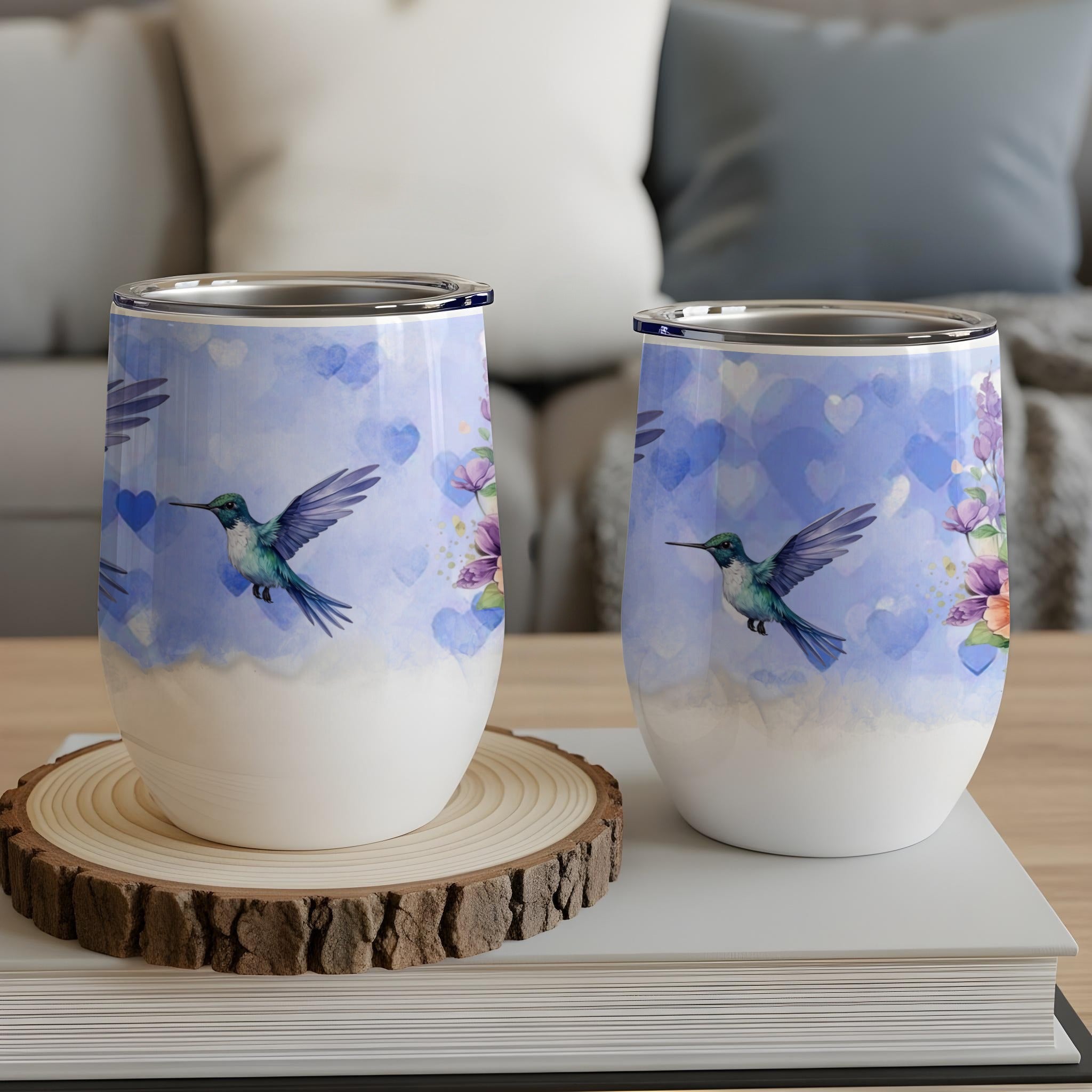 Two stemless wine glasses with hummingbirds, hearts, and floral designs.