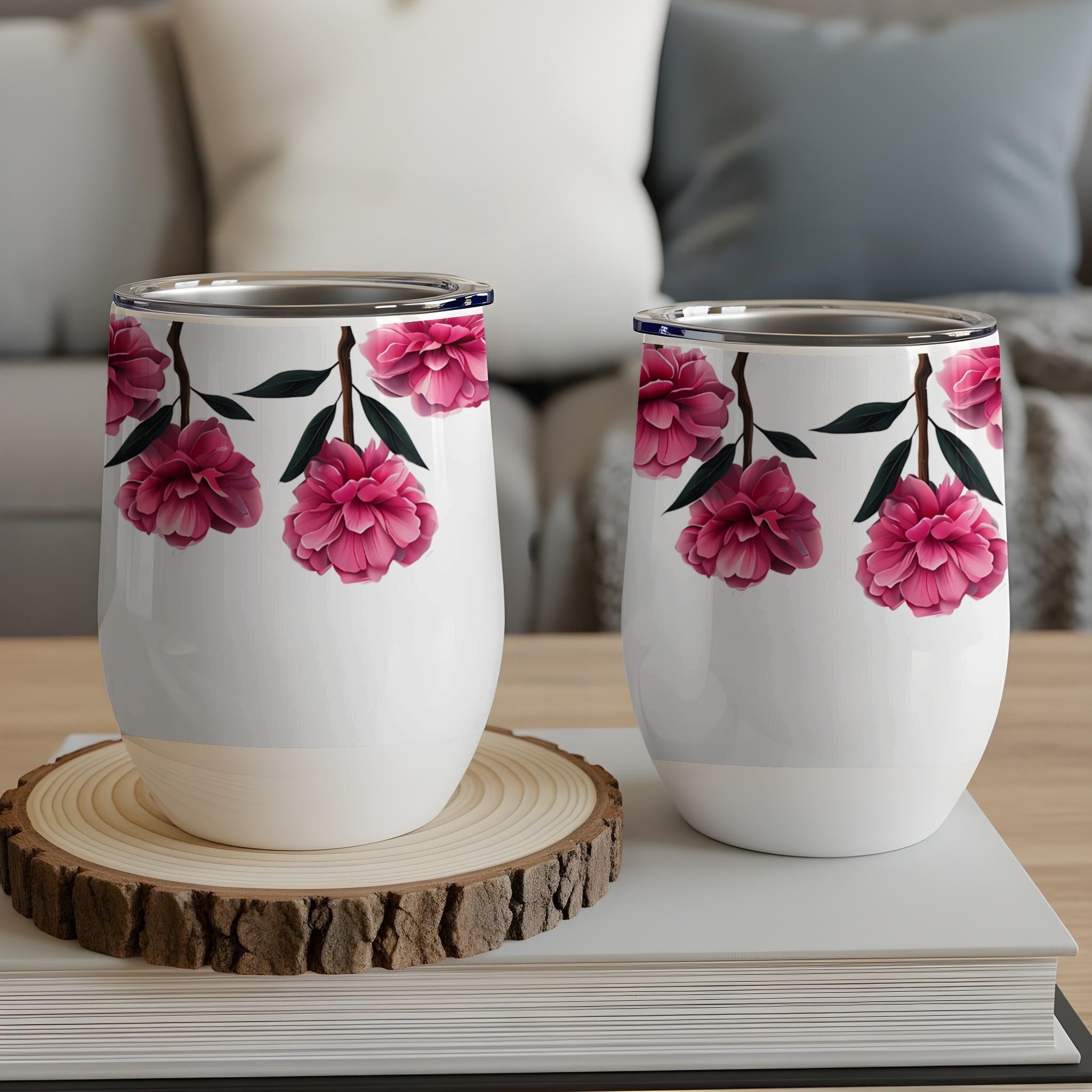 Two white tumblers with pink floral design on a wooden coaster.
