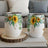 Two white tumblers with sunflower and eucalyptus floral design.