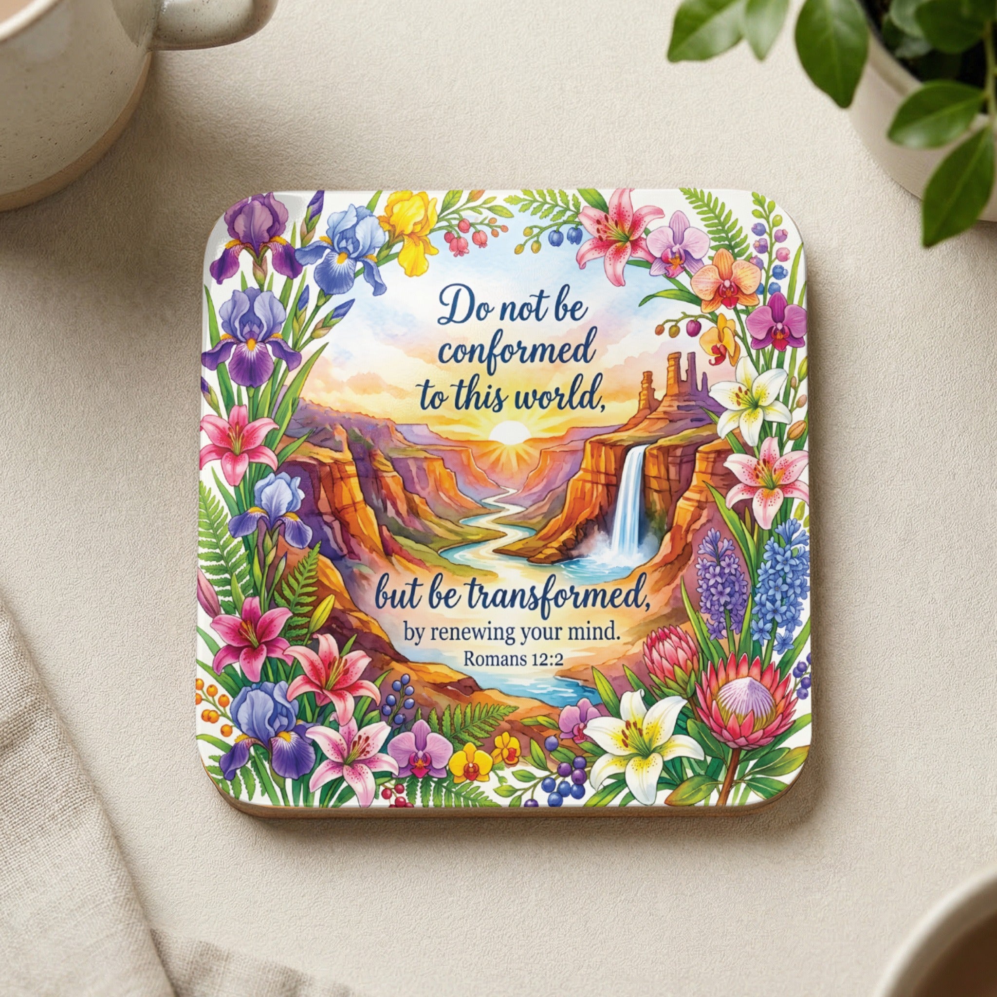 Coaster with colorful floral border and sunset landscape, featuring scripture Romans 12:2.