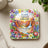 Coaster with colorful floral border and sunset landscape, featuring scripture Romans 12:2.