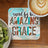 Coaster with "saved by his AMAZING GRACE" text on distressed wood background.