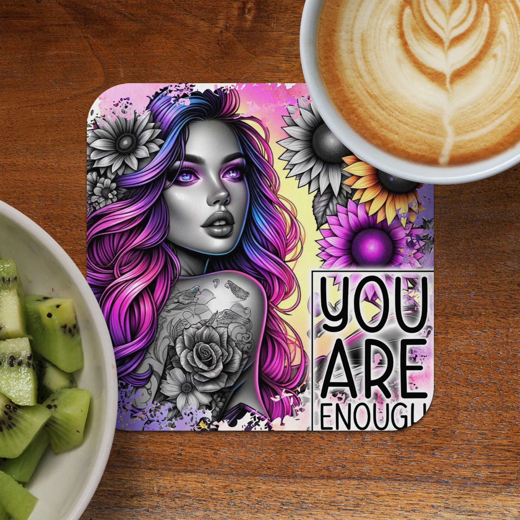 Woman with vibrant hair and floral tattoos on coaster with "YOU ARE ENOUGH" text.