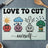 Cutting board with cartoon vegetables and "Love to Cut Ourselves" text.