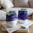 Two tumblers with abstract purple and teal swirl designs sit on books.