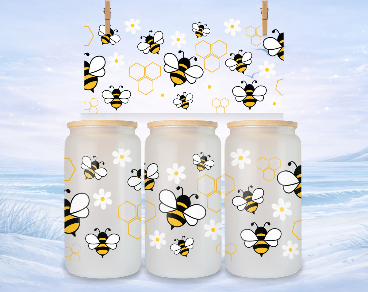 Three frosted glass tumblers with bee and honeycomb designs.