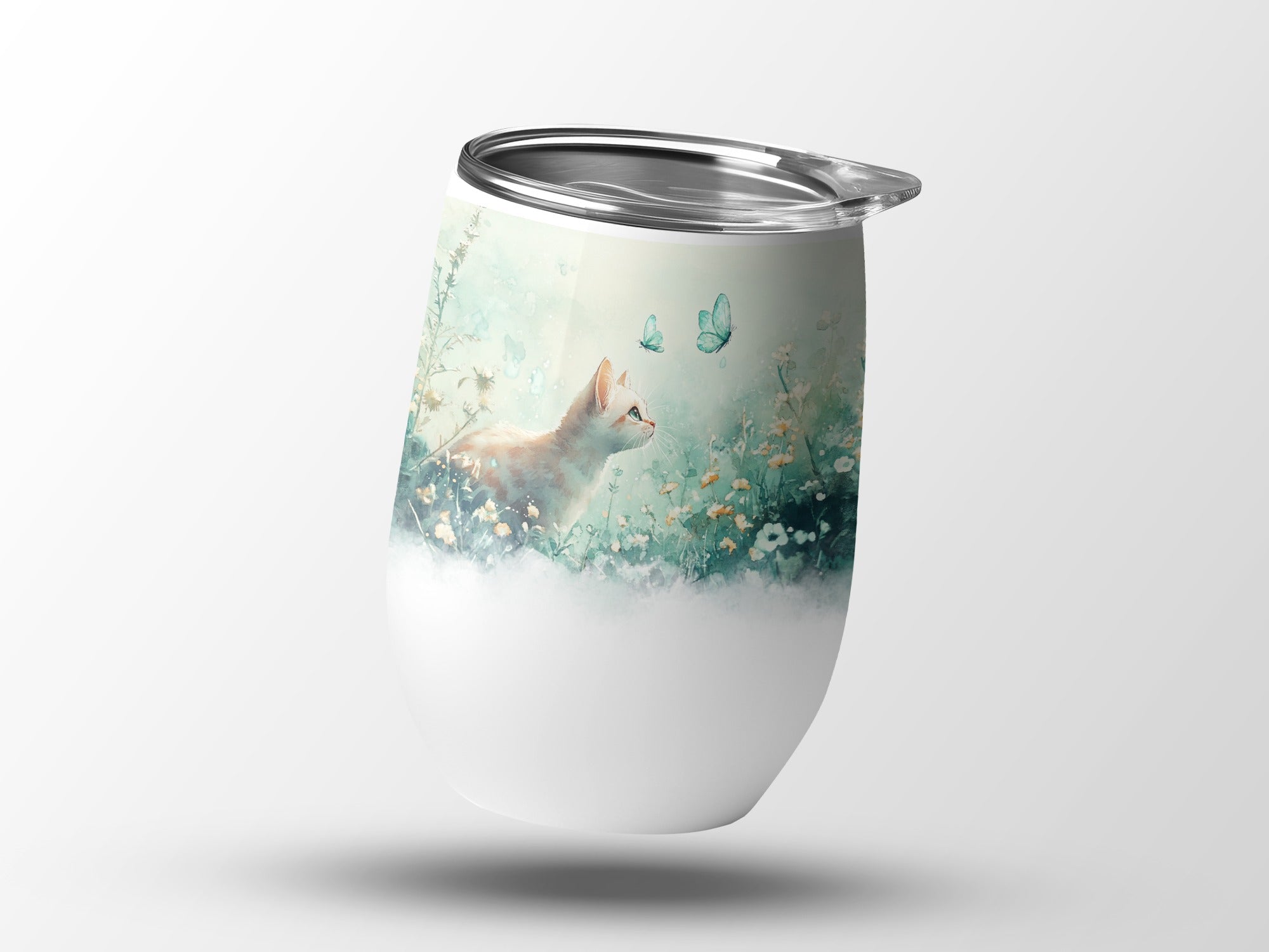 White tumbler with a painting of an orange kitten surrounded by butterflies and flowers.