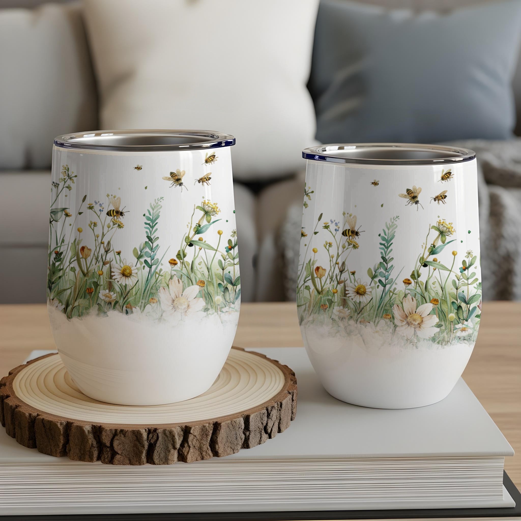 Two white wine tumblers with a watercolor floral and bee pattern.