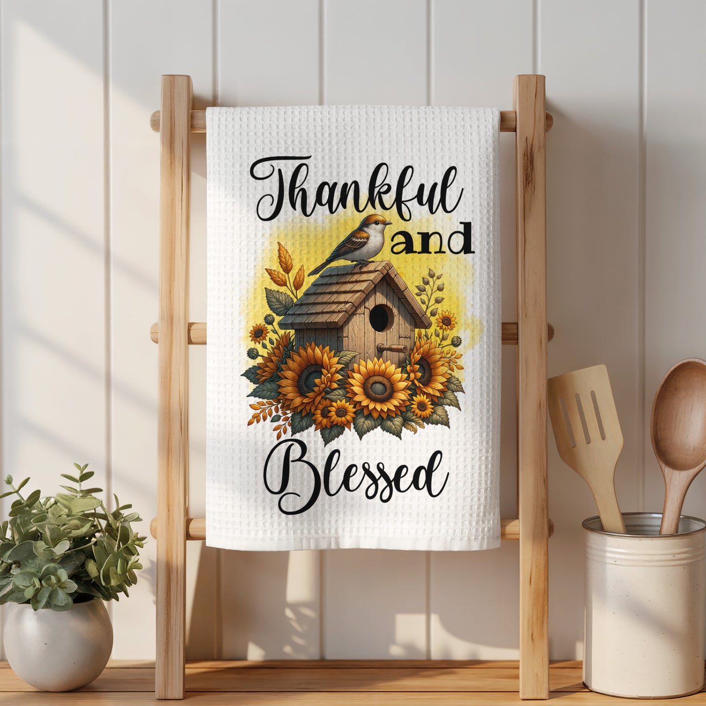 White kitchen towel with sunflowers, birdhouse, and "Thankful and Blessed" text.