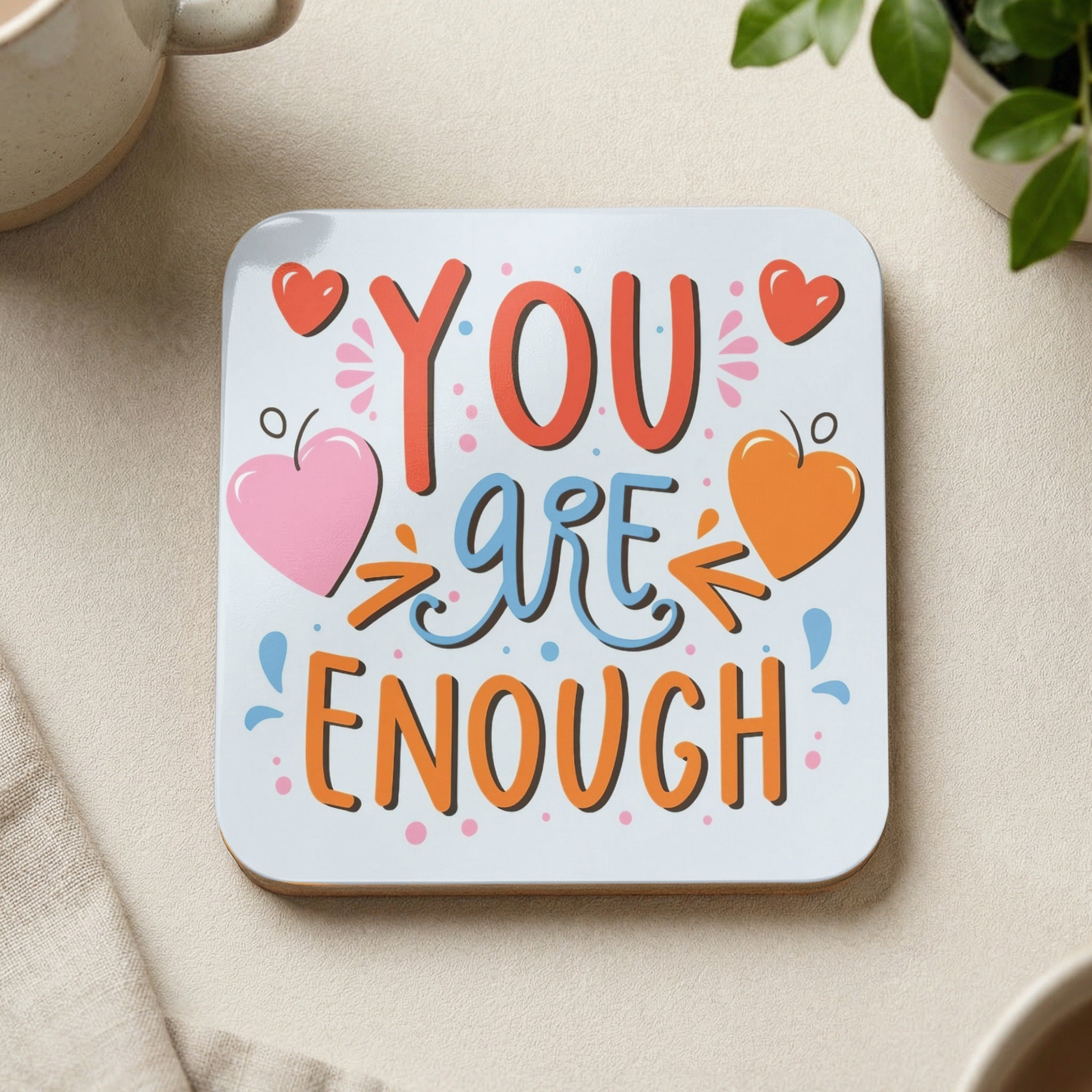 Coaster with "YOU are ENOUGH" text and colorful hearts.