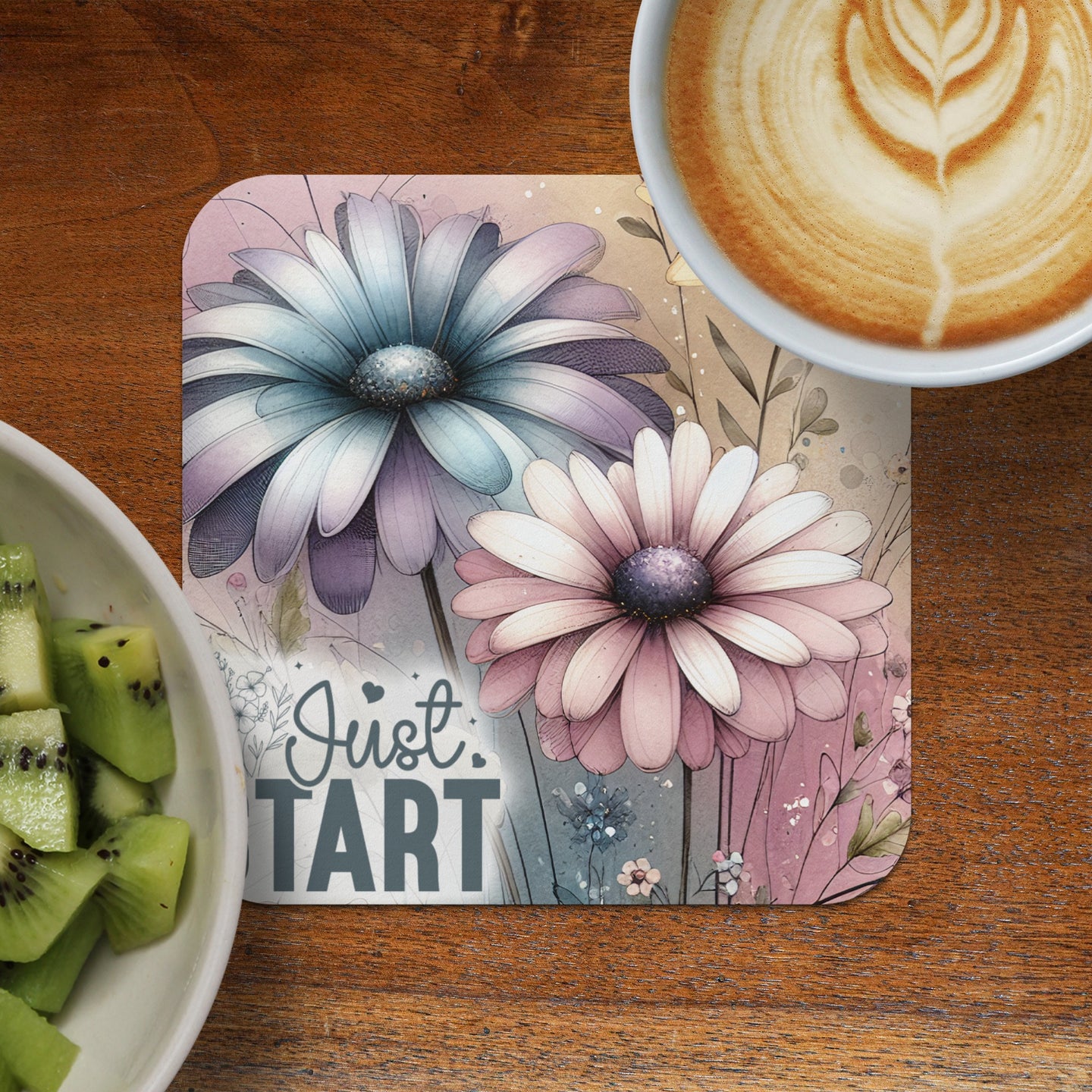 Coaster with two watercolor flowers and text "Just Tart" next to kiwi slices and coffee.