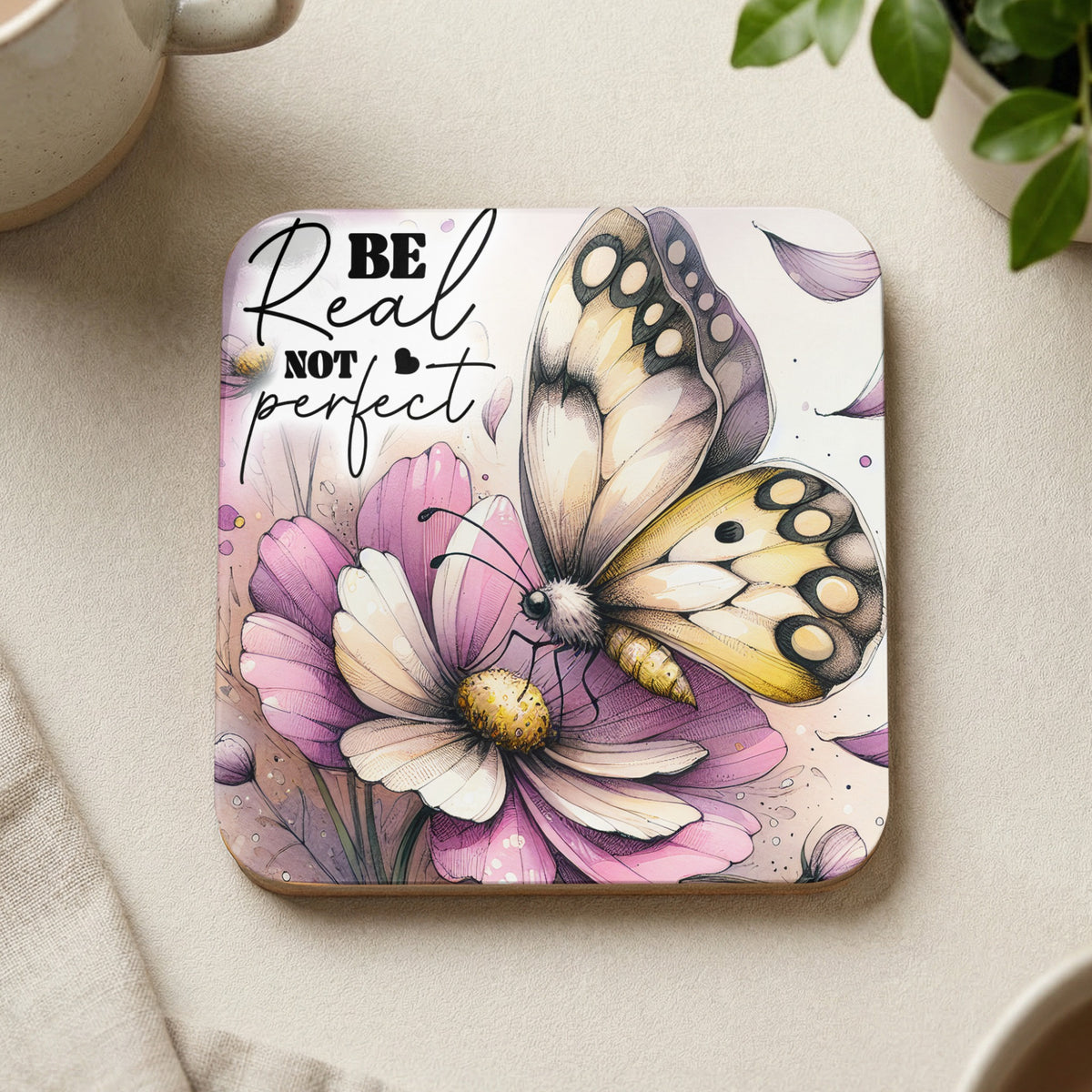 Coaster with butterfly on flower, text "Be real not perfect."