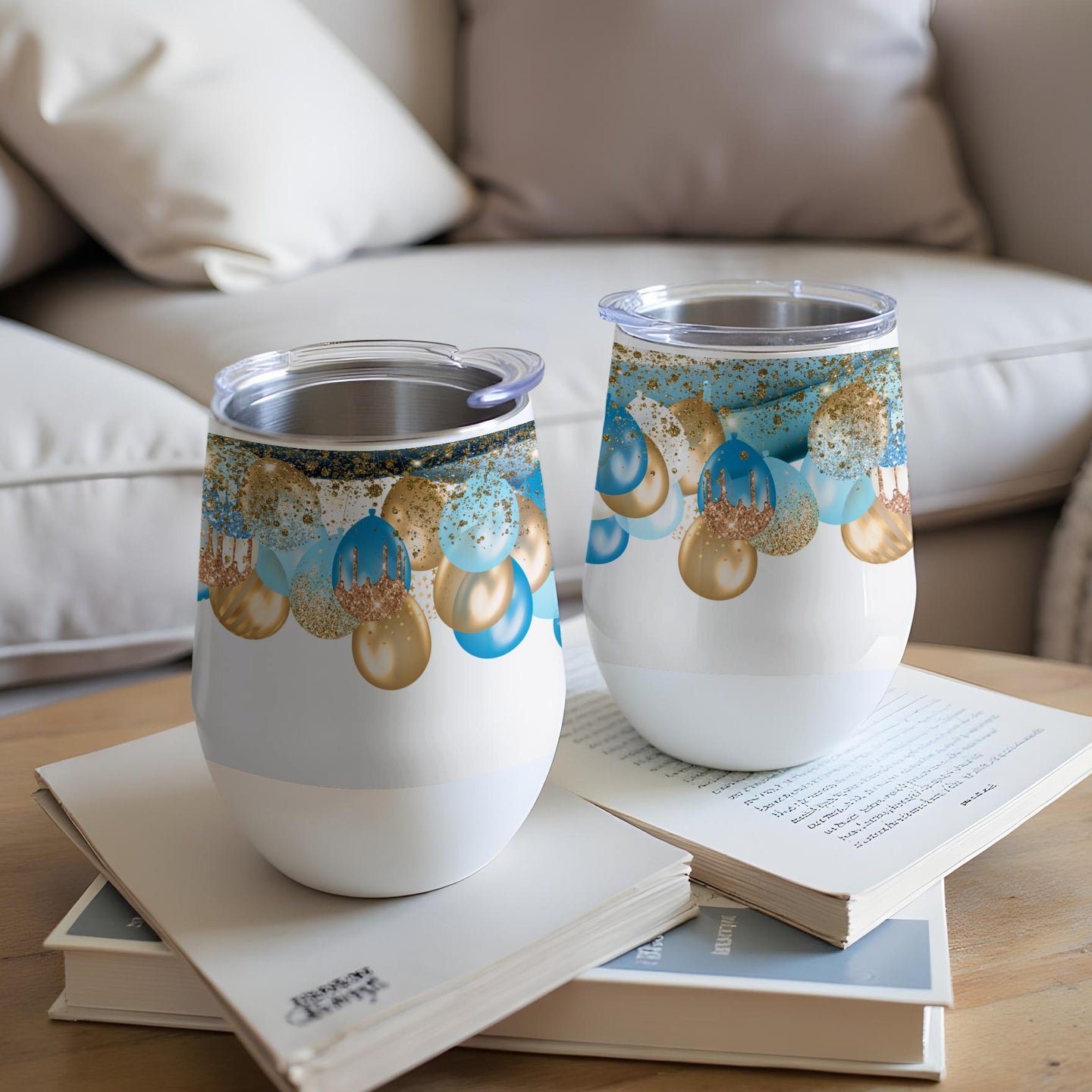 Two white insulated tumblers with gold and blue balloon design.