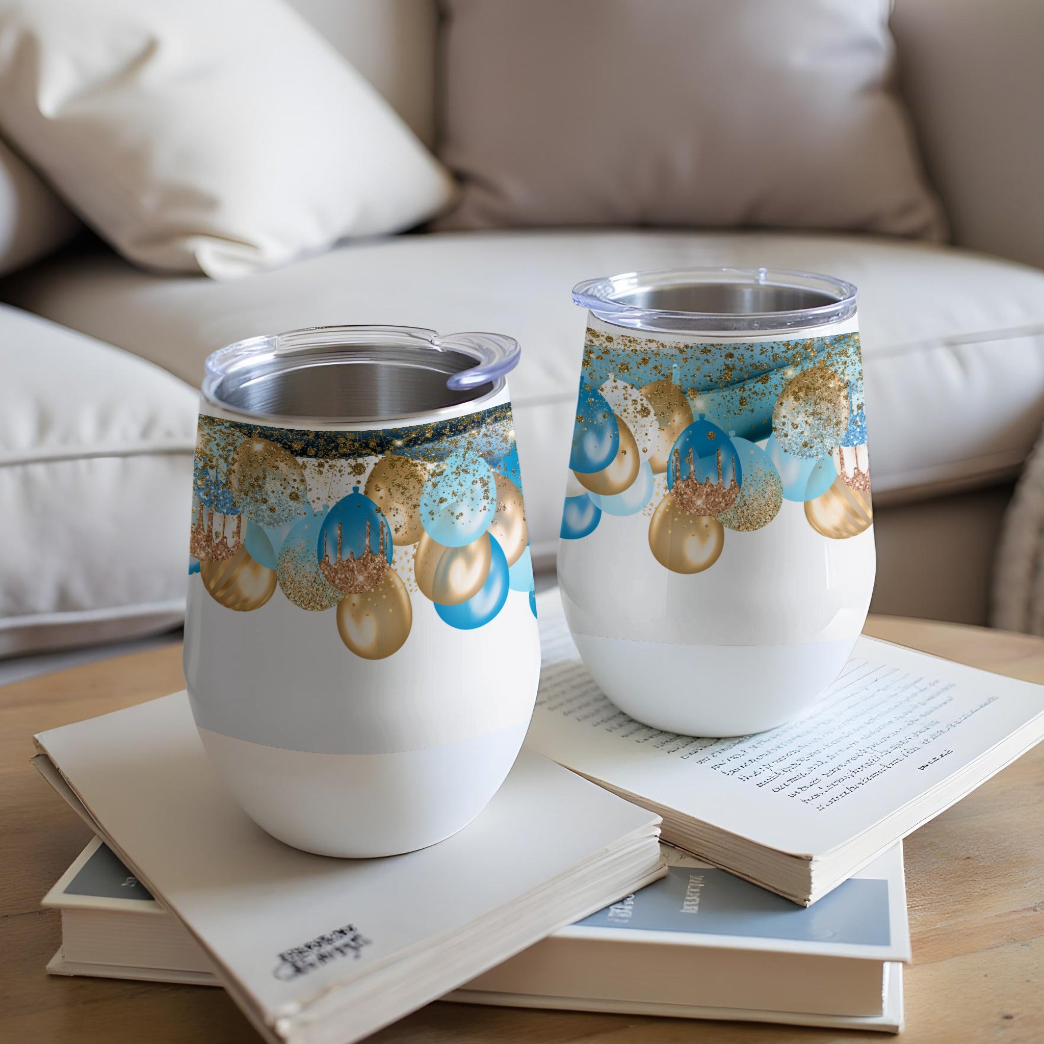 Two white insulated tumblers with gold and blue balloon design.