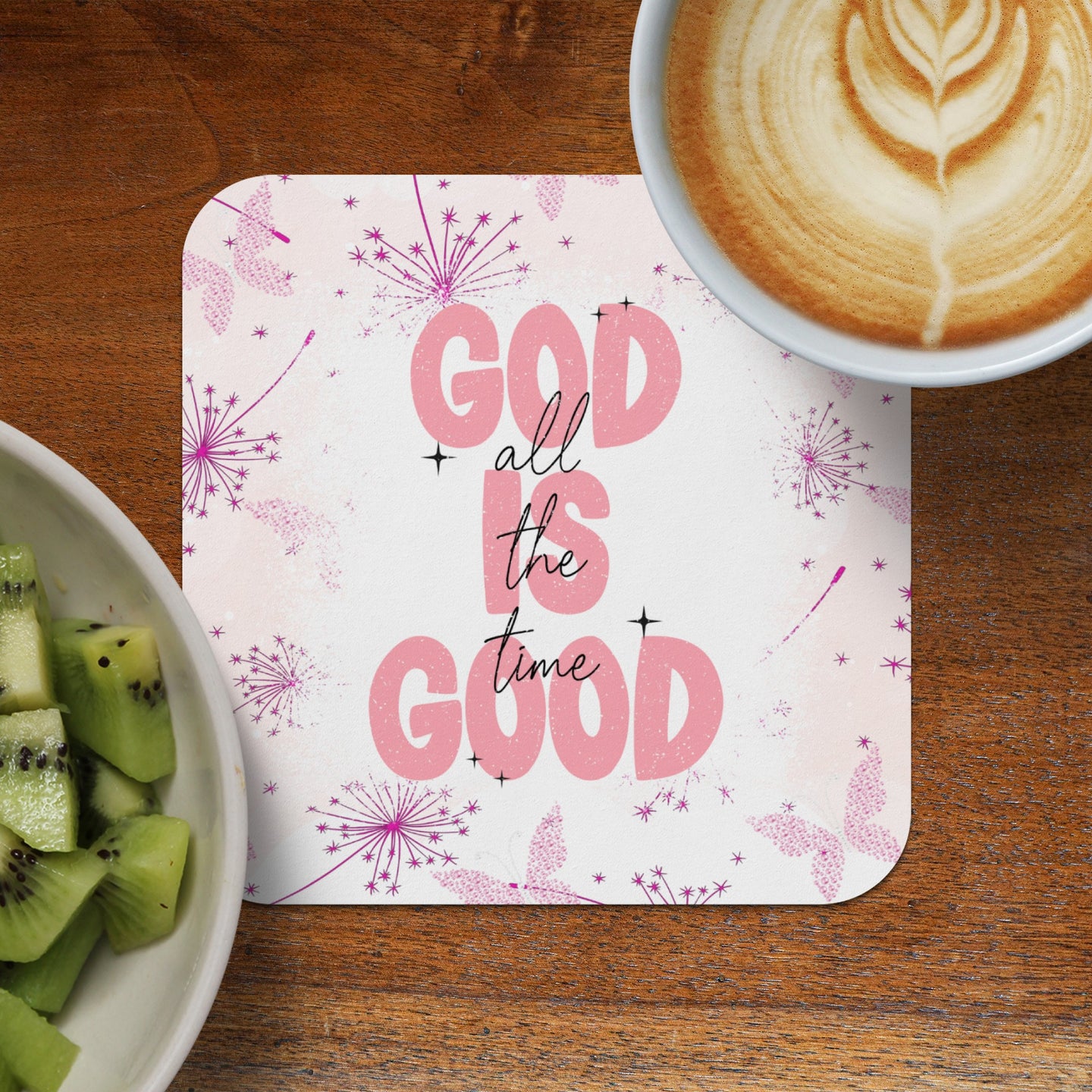 Round coaster with "God is good all the time" text, coffee, and kiwi.