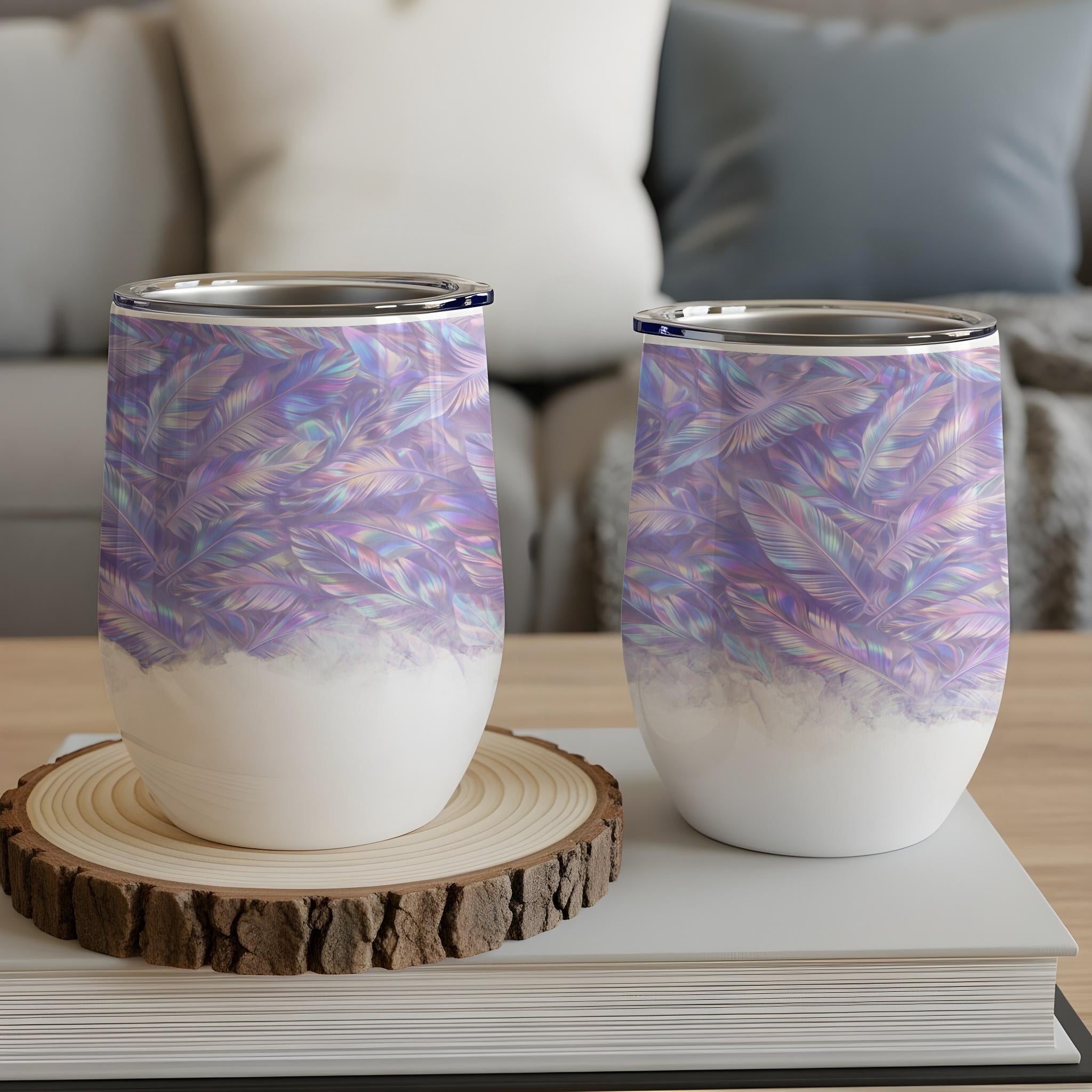 Two stemless wine tumblers with iridescent feather pattern on a wooden coaster.